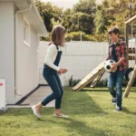 Kids happily playing with a soccer ball outside in their yard with a Bryant air conditioner nearby, representing the benefits of a new HVAC system.