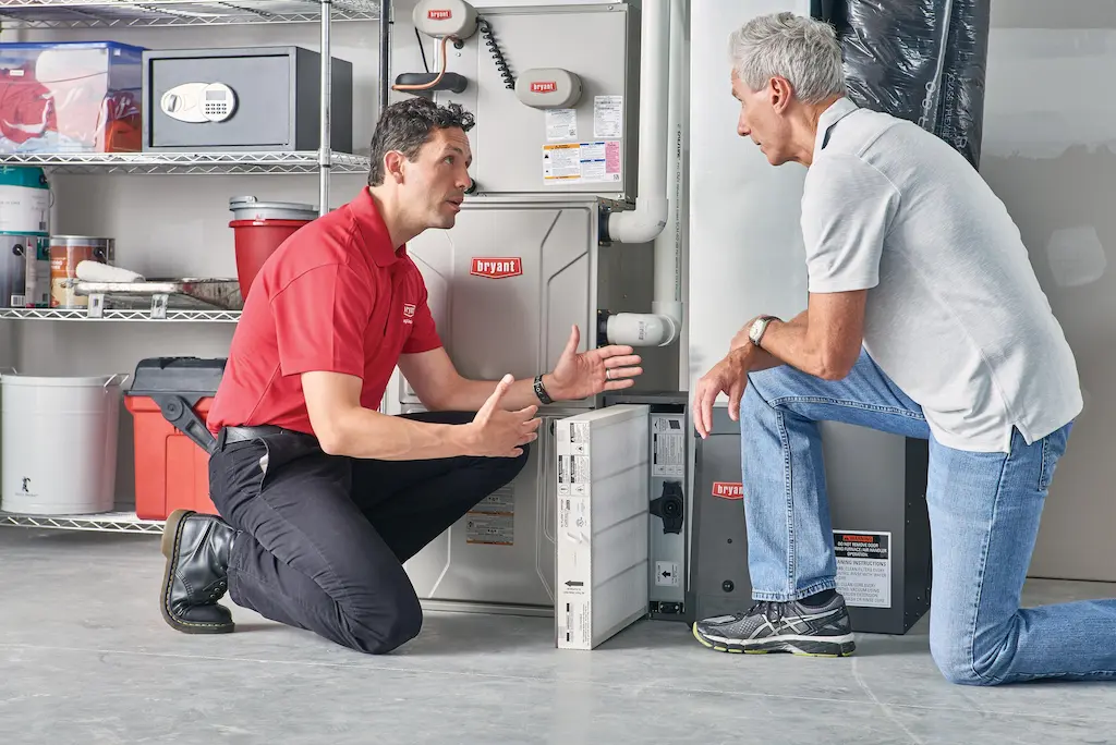An HVAC technician discusses air filter repair with a homeowner as part of the conversation around how much does HVAC repair cost.