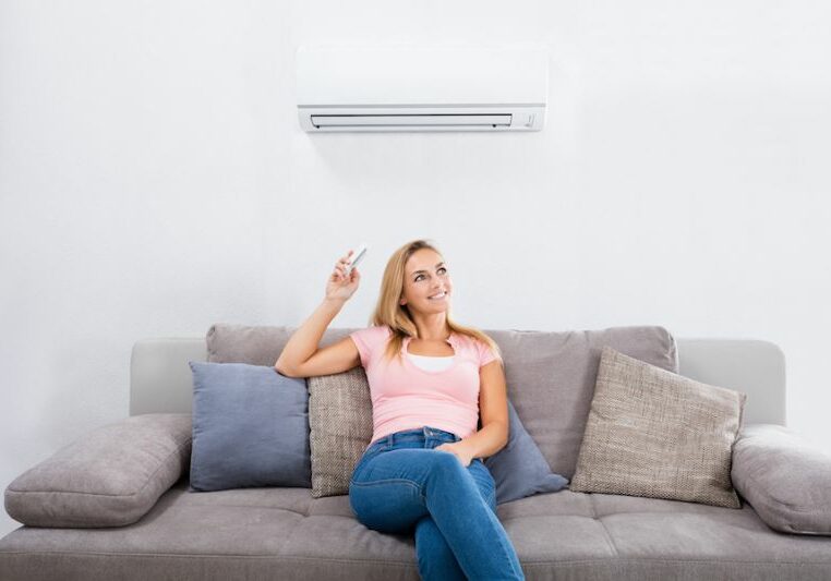Image of person sitting below ductless system. Ductless ACs Improve Indoor Air Quality and Control Humidity.