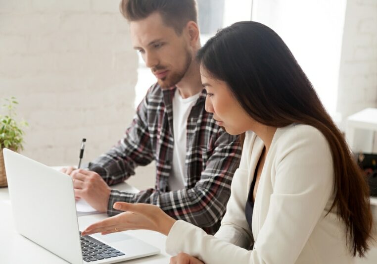 Common AC Purchasing Mistakes. Couple sitting together on a computer, planning an AC purchase.