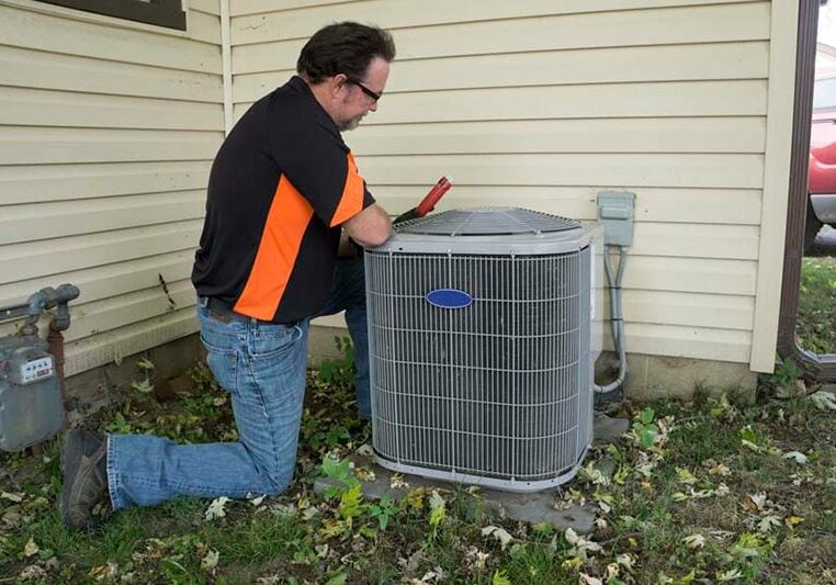 Image of technician working with AC unit. Do I Really Need an AC Tune-Up?